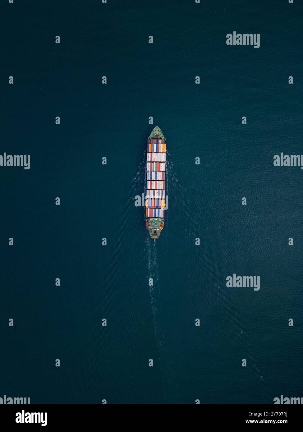 A container ship sails across the calm blue waters Stock Photo - Alamy
