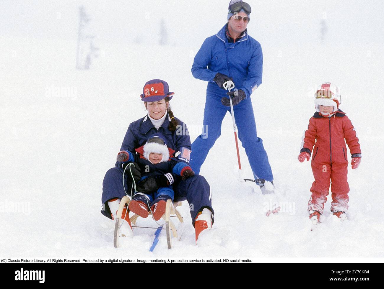 Carl XVI Gustaf, King of Sweden and family skiing 1981.  The King Carl XVI Gustaf, Queen Silvia their children, crown princess Victoria and prince Carl Philip pictured sitting on a sledge and skis. Stock Photo