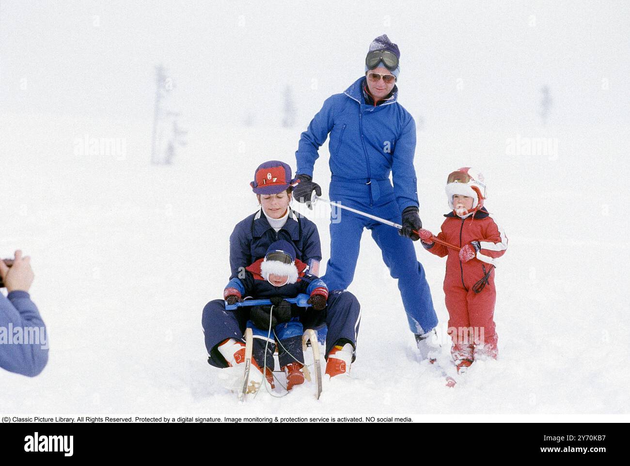Carl XVI Gustaf, King of Sweden and family skiing 1981.  The King Carl XVI Gustaf, Queen Silvia their children, crown princess Victoria and prince Carl Philip pictured sitting on a sledge and skis. Stock Photo