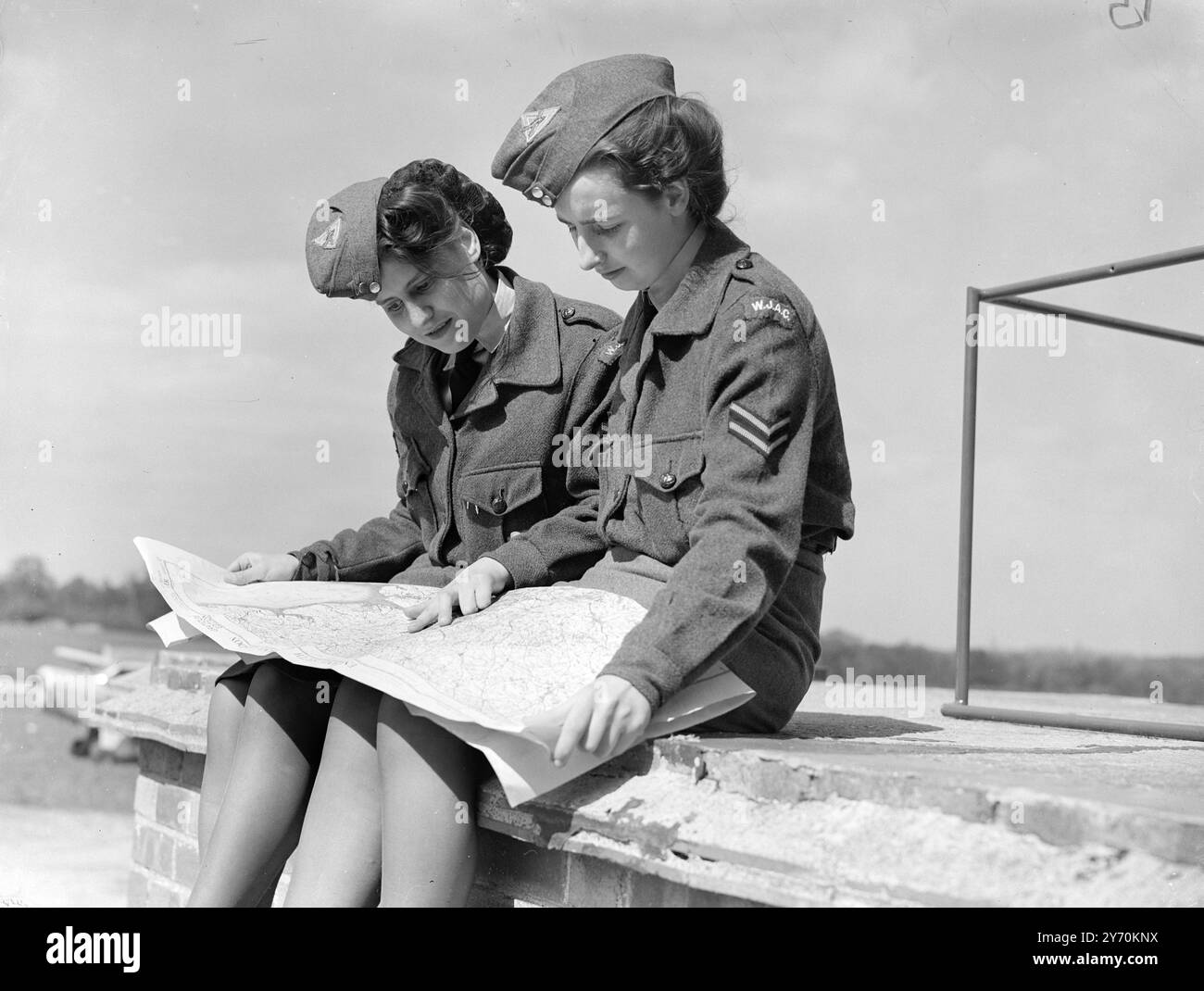 AIR GIRLS TRACE THEIR ROUTE    Two members of the Women's Junior Air Corps at Elstree Airfield ( Herts. ) - Dorothy Knowles  ( left ) and Joan Lee , of Dagenham , study a map of the area during the Elementary Lessons they are undergoing in flying . The flying season started at Elstree today , and about 100 girls aged from 14 to 20 , will have the opportunity of going up in the Corps ' own aircraft  '' Grey Dove '' , which was named by the Duchess of Kent at the Corps ' big national rally last summer .     23 April 1949 Stock Photo