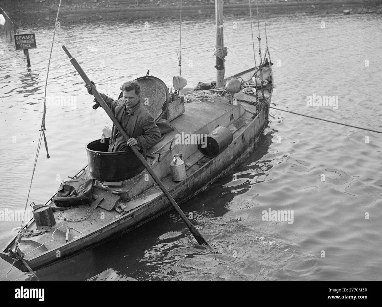 HE PLANS TO SAIL ROUND THE WORLD ON HOME - MADE BOAT    Man who hopes to fulfil a dream of 11 years ago , is Vladimir Vestanowitch , who is planning to sail around the world in  home made boat . His craft is the Orlan , a tiny all - steel Bermuda rigged sloop of his own design, made by himself and now lying in the Old Parish Dock at Portished ( Somerset ) .  The Orlan has a circular hatchway like the conning tower of a submarine in place of the usual helm smart cockpit .  Vladimir's heavy weather plans are simple . He will drop a sea anchor , crawl below and seal himself in by closing the circ Stock Photo