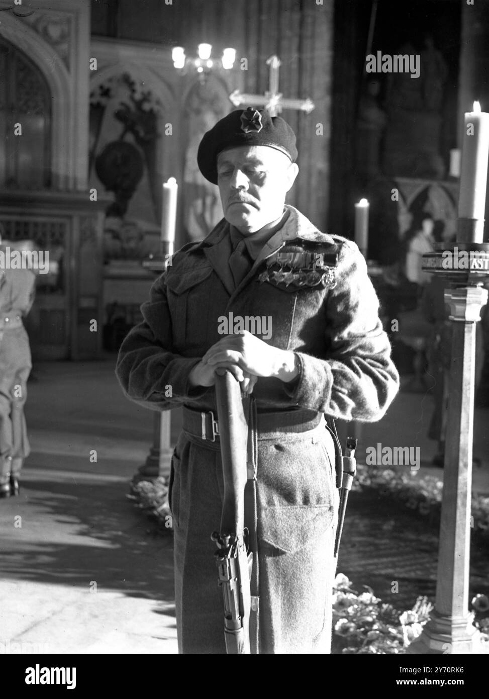 In Westminster Abbey today a rehearsal took place for the ceremony in which a guard of honour , provided by the 11th County of London Home Guard Battalion , will mount guard on the Unknown Warrior's Tomb on Remembrance Day , Sunday 9 November 1952 .The guard will consist of four sentries , one posted at each corner of the tomb . Seen here in a solemn attitude , Private Patrick Susands , a Londoner and an ex Sgt Major , rests on his upturned rifle during today's rehearsal . 6 November 1952 Stock Photo
