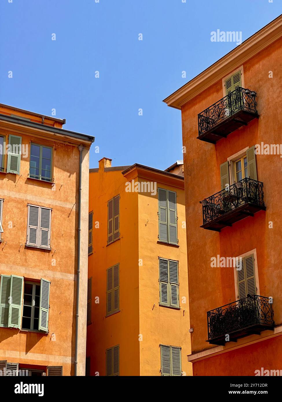 Old residential buildings with warm-toned facades and wrought iron balconies. Authentic Mediterranean atmosphere in a European old town - Smartphone Captured Stock Image