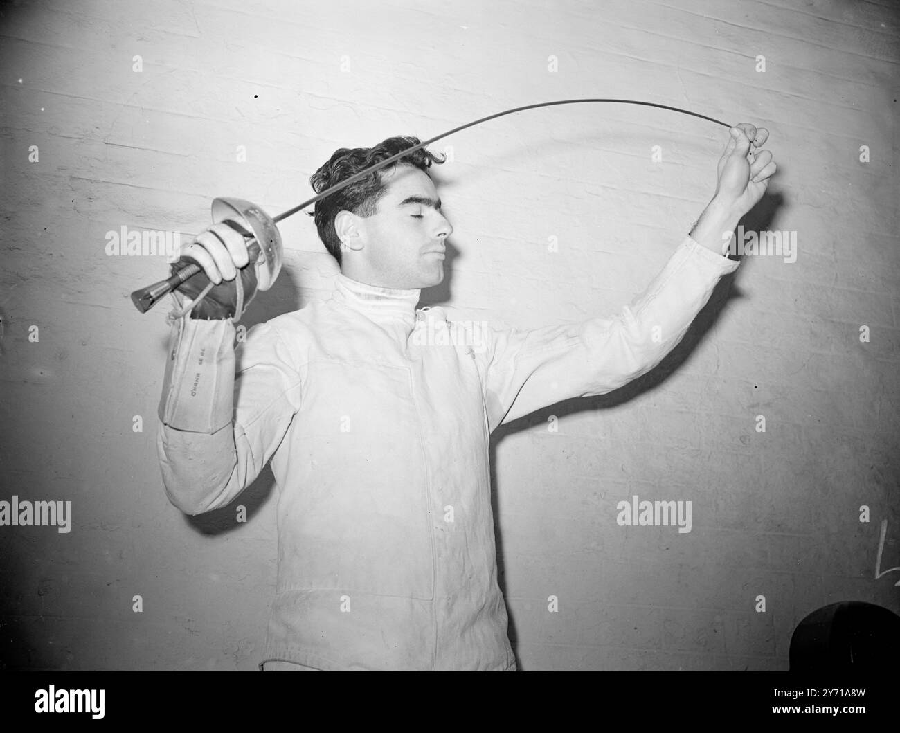 TESTING BEFORE COMPETING   Twenty - one year - old E.J. O ' HANA , ( Loughborough College ) , Leicester , testing his epee before competing in the Universities A.U. championships at the London Fencing Club . O' Hana was born in Spain and his parents are living in Portugal .     12 February 1949 Stock Photo