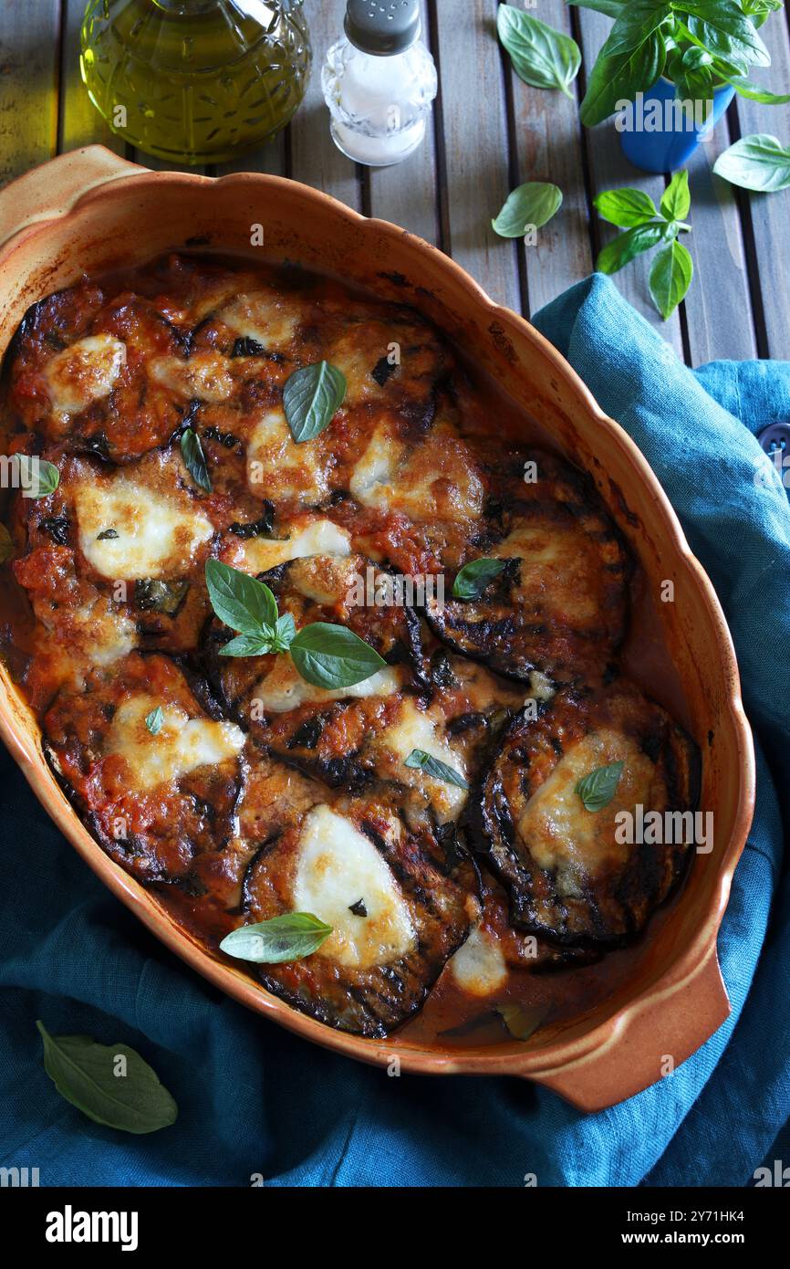 Baked aubergine parmigiana. Dish based on aubergines, tomato puree, fresh basil leaves, garlic, parmesan and mozzarella. Italian food. Directly above. Stock Photo