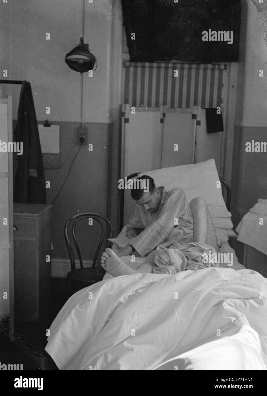 Hospital wartime injured man reading book, bandaged 1945 Stock Photo