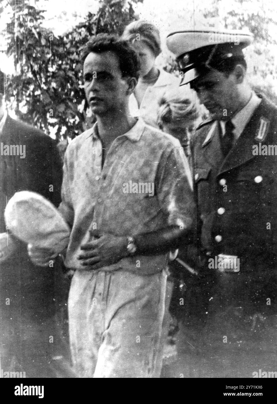 One of the three East German bricklayers engaged on building the East German border wall who fled over the border pictured with a West German policeman as he arrived in West Berlin 3 October 1961 Stock Photo