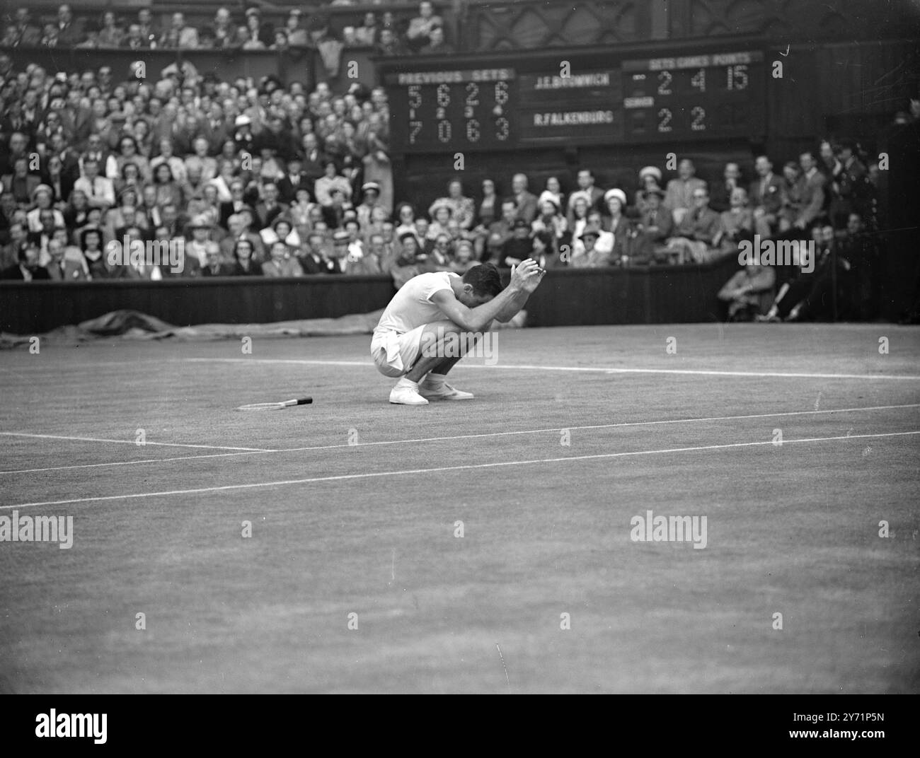 ' Falkenburg New Champion : Beats Bromich at Wimbledon '   Twenty-two year old Robert Falkenburg , the fast serving Californian , became the new Men's Singles champion at Wimbledon today. He wont 7-5 , 0-6, 6-2 , 3-6 , 7-5 , over Australia's John Bromich.    Picture shows :  'Victory prayer' - America's Robert Falkenburg crouches during his final with Bromwich on the Centre Court today.     July 2 1948 Stock Photo