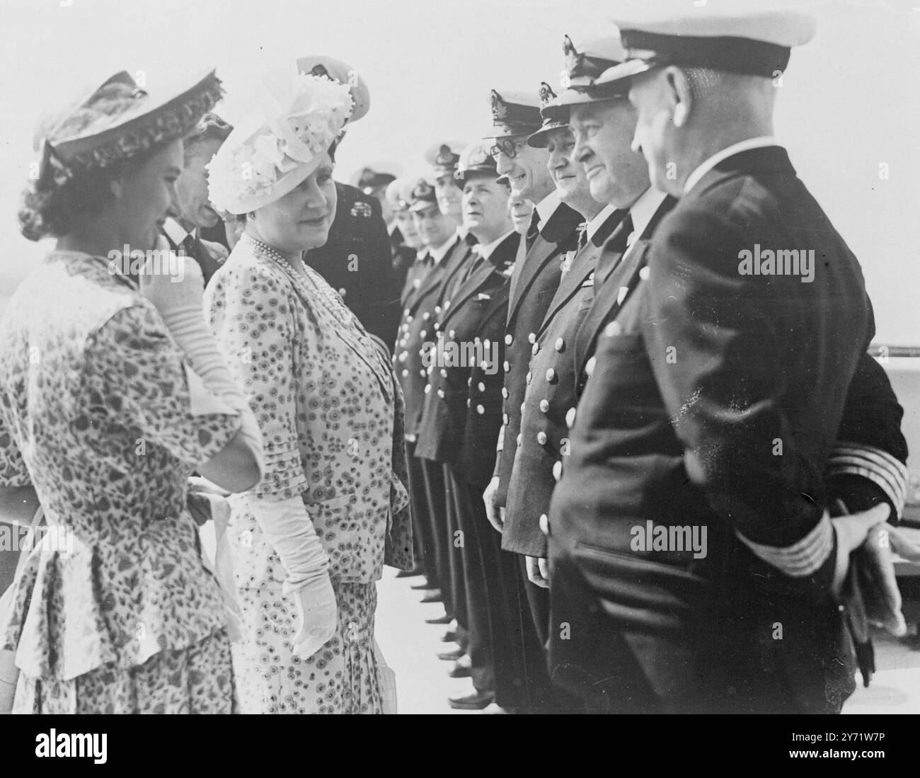 Their Majesties with Princess Margaret visit the 'Queen Elizabeth'.   Their Majesties the King and Queen, accompanied by HRH Princess Margaret, paid a visit to Southampton for an informal visit to the Cunard White Star Liner 'Queen Elizabeth'. They inspected the new picture of HM the Queen by Mr Oswald Birley, which hangs in the ship's lounge.     Picture shows : HM the Queen and Princess Margaret talking to the ships' officers aboard the 'Queen Elizabeth'.    28 July 1948 Stock Photo