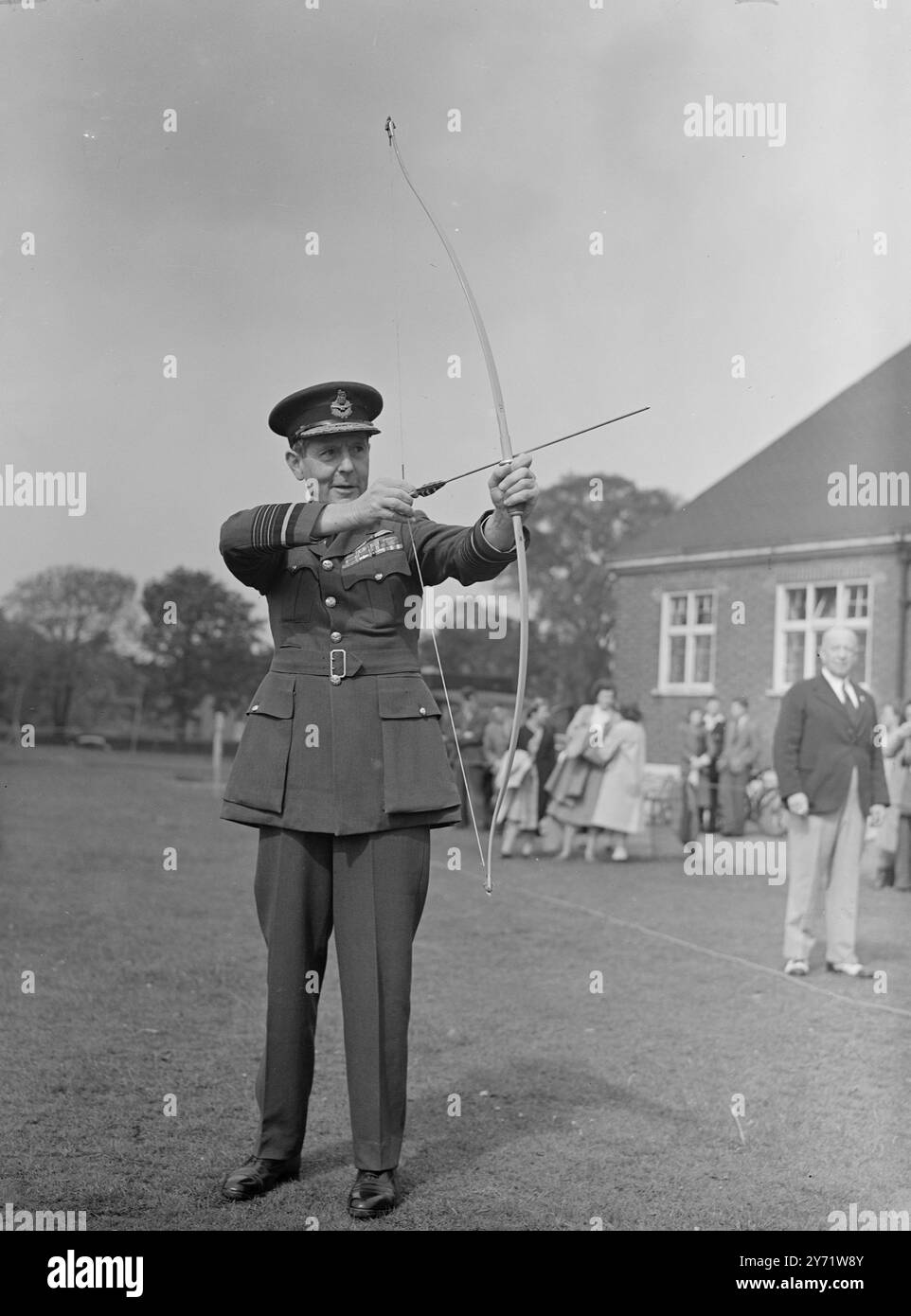 Shades of merry England.    Eleven countries, including America, Czechoslovakia, are taking part in the 12th International Archery Tournament for the Championships of the World in the grounds of Dulwich College. The tournament started today and continues until Saturday. Members of the archery clubs associated with The Grand National Archery Society have been practising hard for this important event where eye and muscular co-ordination are the needful qualities.     Picture shows : Air Chief Marshal Sir Philip Joubert shoots an arrow and declares the tournament open today.     10 August 1948 Stock Photo