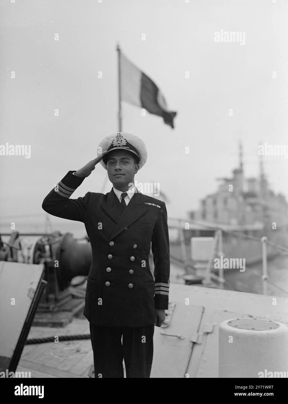 Pakistan ship at Portsmouth.   The 1,700 ton frigate Jhelum, the first ship to visit Britain of the newly formed navy of the Dominion of Pakistan, has arrived at Portsmouth, with the advance party of personnel to man the two destroyers that Pakistan is buying from Britain. Originally commissioned in this country in 1943, the Jhelum was given to the Royal Indian Navy and then handed over to Pakistan after the partition of India.  Picture shows : The ship's Captain, Commander Abdul Rashid, takes the salute aboard the frigate Jhelum with Pakistan flag flying behind him.   1 September 1948 Stock Photo