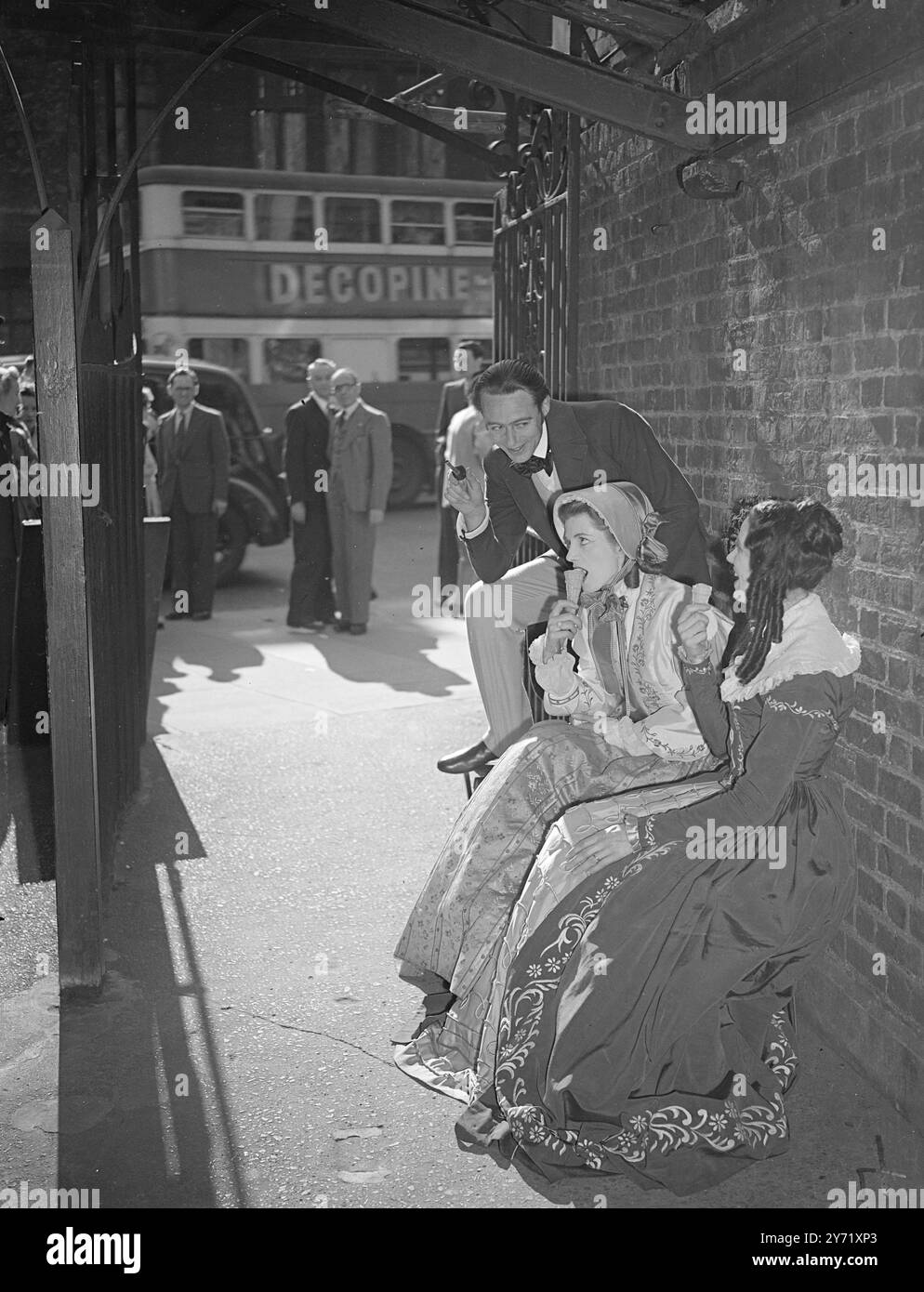 " WATCH OUT FOR PAPA BARRETT !"     EDWARD MOULTON-BARRETT is in for an apoplectic fit if he comes around the corner to find his Daughters , HENRIETTA ( Sarah Churchill ) , centre, and ELIZABETH   (Margaret Johnston) , eating ice cream in the street with that poet fellow ROBERT BROWNING ( Alec Clunes ) . Principals from the cast of " The Barrets of Wimpole Street " at the Garrick theatre, London, found the sunshine too great a temptation today, and had a short Whitsun holiday between shows.    May 15 1948  . Stock Photo