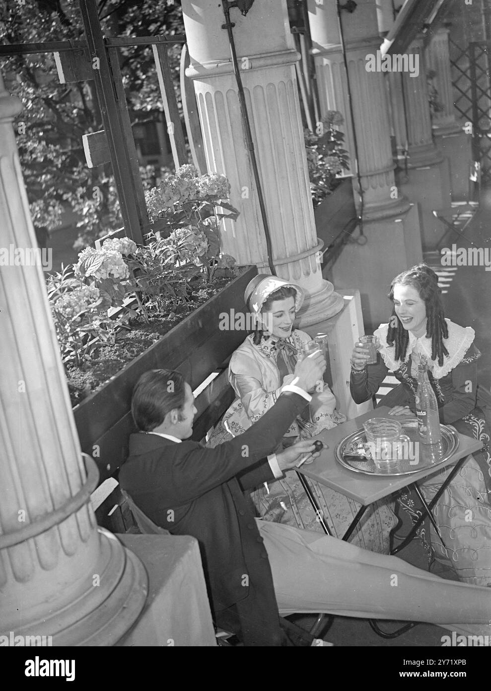 " WATCH OUT FOR PAPA BARRETT !"     EDWARD MOULTON-BARRETT is in for an apoplectic fit if he comes around the corner to find his Daughters , HENRIETTA ( Sarah Churchill ) , centre, and ELIZABETH   (Margaret Johnston) sitting with that poet fellow ROBERT BROWNING ( Alec Clunes ) . Principals from the cast of " The Barrets of Wimpole Street " at the Garrick theatre, London, found the sunshine too great a temptation today, and had a short Whitsun holiday between shows.    May 15 1948 Stock Photo