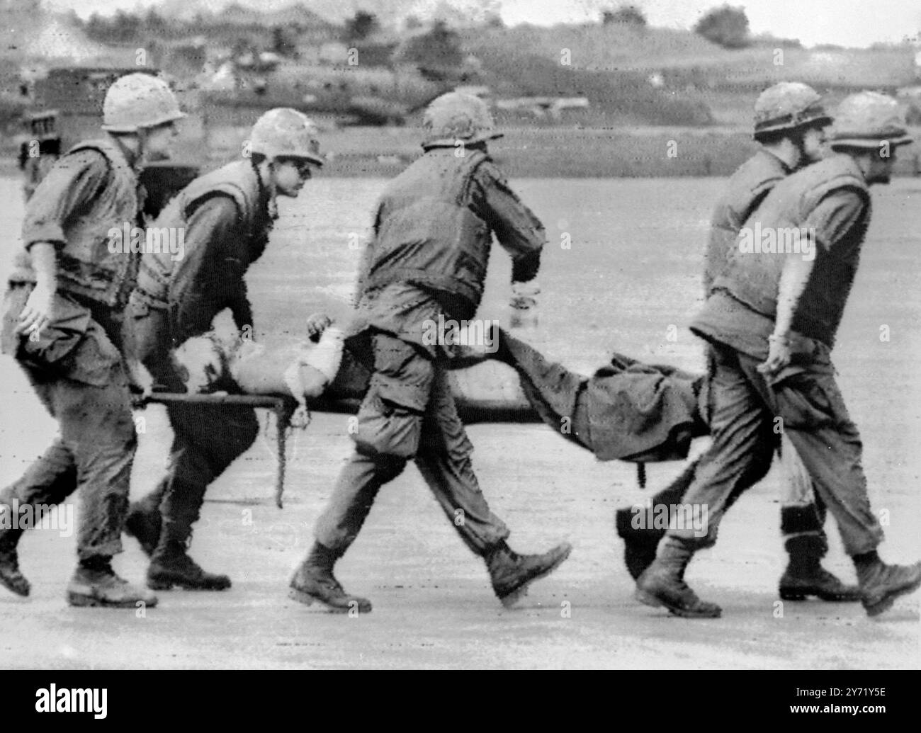 Khe Sanh , South Vietnam :Members of the 1st  Battalion 26th Regiment , 3rd US Marine division , carry a wounded comrade to a helicopter following communist artillery  and rocket attack on the US marine combat base  here  26 January .  The base is located seven miles below the demilitarized zone . 29n January 1968 Stock Photo