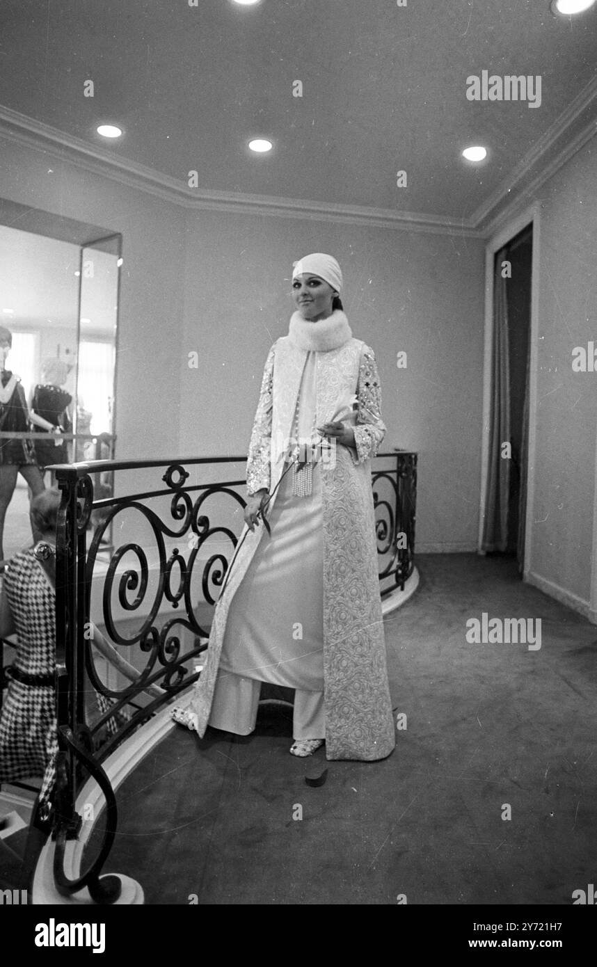 A white silk jersey wedding dress by designer Marc Bohan , shown at the 1969/70 Autumn Winter Collection . To wear over it , a coat in white silk broche showing metal sequins embroideries . The headscarf is also in white silk jersey , Paris , France . 1 July 1969 Stock Photo