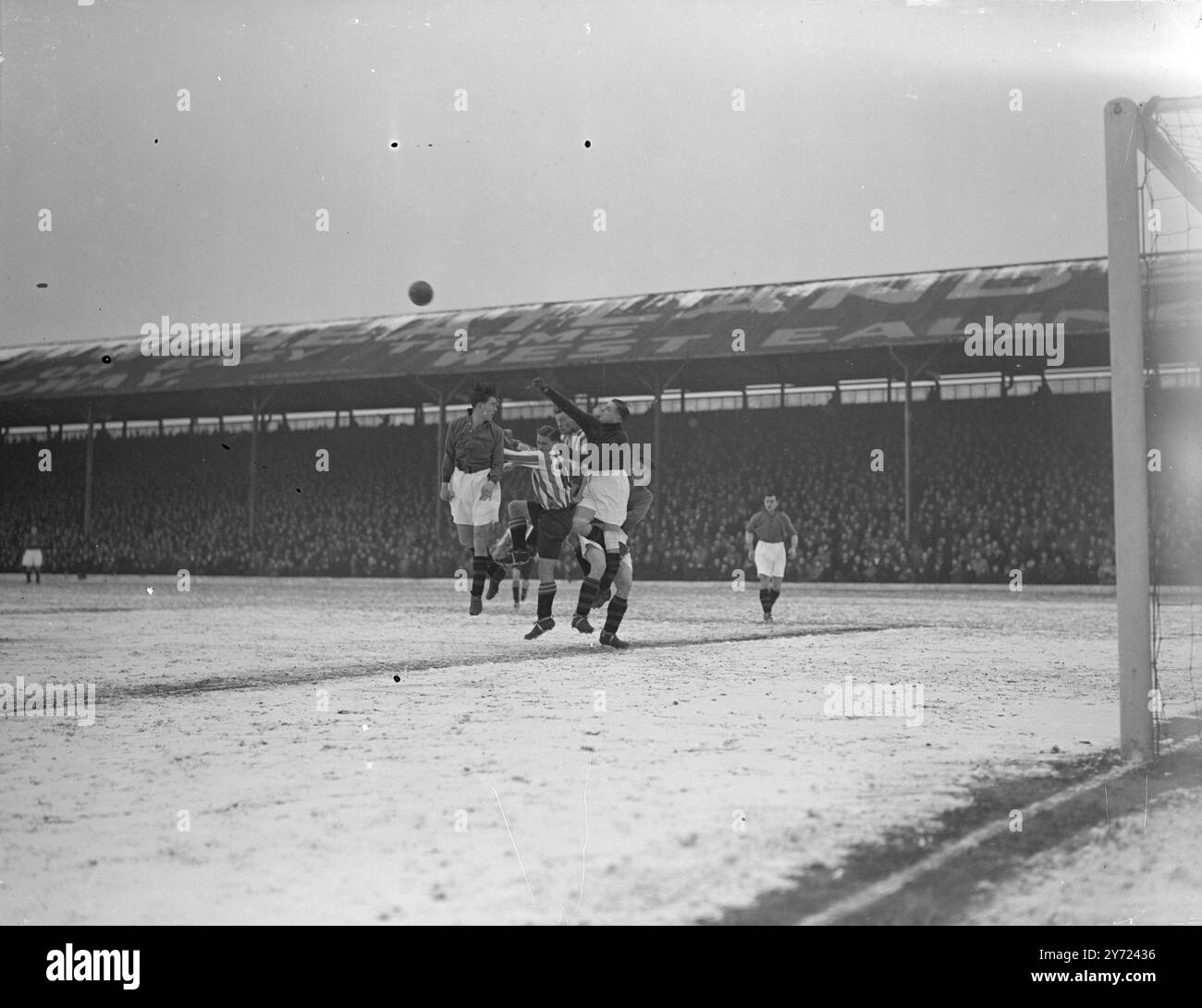 Football: Brentford v. Plymouth.   Brentford were at home to Plymouth in Second Division fixture at griffin park, Brentford, this afternoon (Saturday).  Picture Shows: Shortt, the Plymouth goalkeeper, punches clear from a melee in front of his goal on the snow-covered ground at Brentford today (Saturday).      21 February 1948. Stock Photo