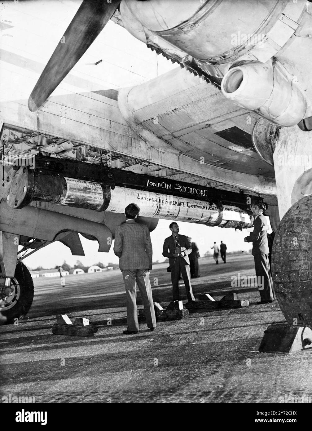 A four engined Halton aircraft, civil version of the Halifax bomber, left Bovingdon Airfield, Hertfordshire, at midnight last night with a most unusual cargo. Flung beneath the aircraft, a Lancashire Aircraft Corporation machine, is a 5 1/2 ton propeller shaft, looking like a giant block-buster. The shaft is destined for the Western Canada's steamship vessel, S.S. Lake Chilco, lying immobilised at Singapore with its shaft irreparably damaged. Whereas it would take some 60 days to take a shaft out by sea, the Halton is expected to have it on the spot by Sunday, and the steamship company will sa Stock Photo