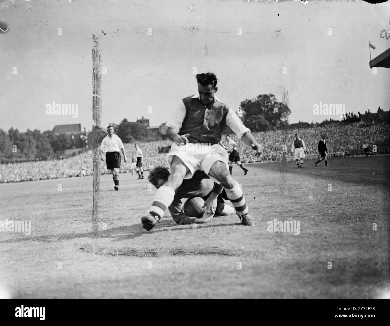 One million soccer fans welcomed the opening of the season when a full table of matches was played in all departments of the English and Scottish Leagues. Highbury Stadium was packed with spectators eager to see the Arsenal open the season against Sunderland, with Roper, £11,000 right-winger from Southampton, and £10,000 Macaulay right half from Brentford, making their first appearance for the London side. Picture shows: Sunderland goalkeeper Matson dives to hold the ball at the feet of McPherson, the Arsenal outside left, during this afternoon's game at Highbury  23 August 1947 Stock Photo