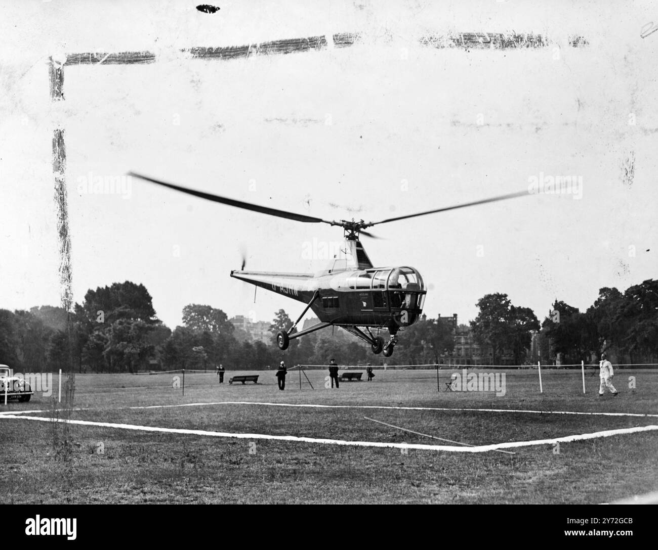 A Westland Sikorsky S.51 helicopter took the place of the usual home -to-office train this morning for Mr G.S. Lindgren, Parliamentary Sec to the Ministry of civil aviation. From a field near his home in Welwyn Garden City, piloted by Mr J.L. Bristol touched down at Regents Park for an experiment sponsored by the government which is buying three of the machines for general use, may well be the fare-runner of an accepted method of transport from suburban homes to London offices.  Picture shows: the helicopter comes slowly down into the small landing area marked off for it in Regents Park.   27 Stock Photo