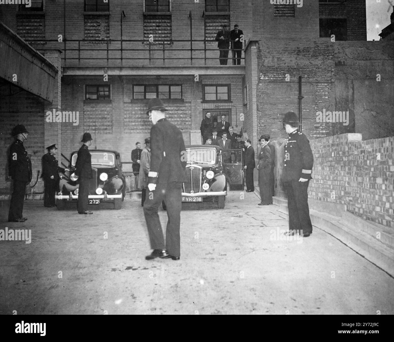 Three young men appeared at Gret Marlborough street Magistrates Court today, charged with the murder by shooting of Alec de Antiquis during a raid on a jewellers' of Charlotte Street, three weeks ago. The three men are Christopher James Geraghty, 20 year old labourer, of Liverpool Road, Charles Henry Jenkins, 23 year old lighterman of Weller House, Abbey Road, and Terrance John Peter Rolt, 17 year old waterhouseman, of St John's Estate Bermondsey. Picture Shows: One of the accused being escorted by detectives to a police car at Tottenham Court road Police Station on the way to Marlborough stre Stock Photo