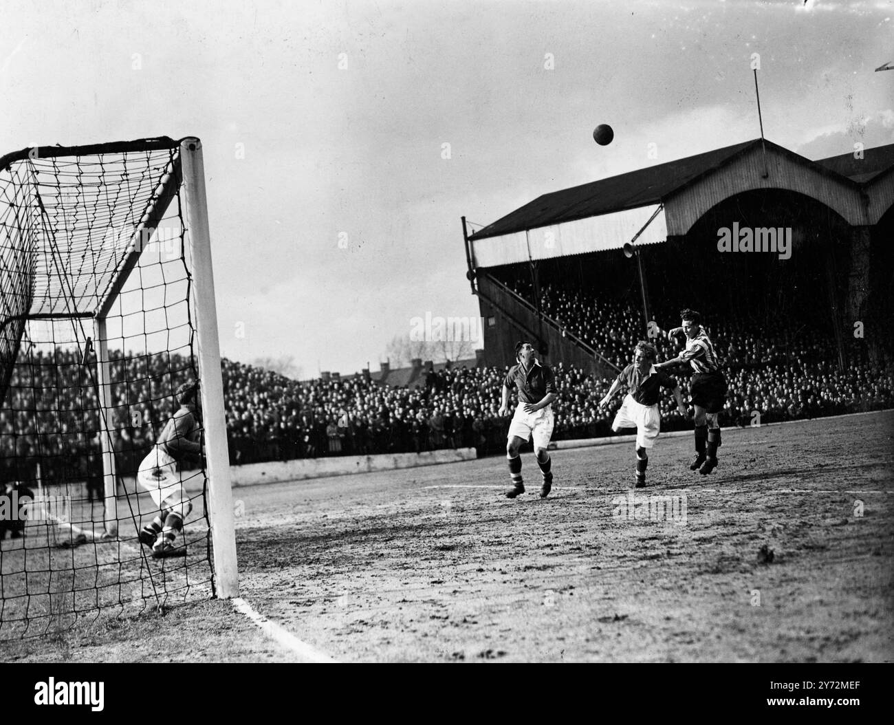 Charlton were playing at home to Brentford at the Valley today. Picture shows: a scene from the match at the Valley today when (left to right) Shreeves, Charlton's left back; Phipps, Charlton's left half, and Macauley, Brentford inside right, go up for the ball around Charlton's goal.  22 March 1947 Stock Photo