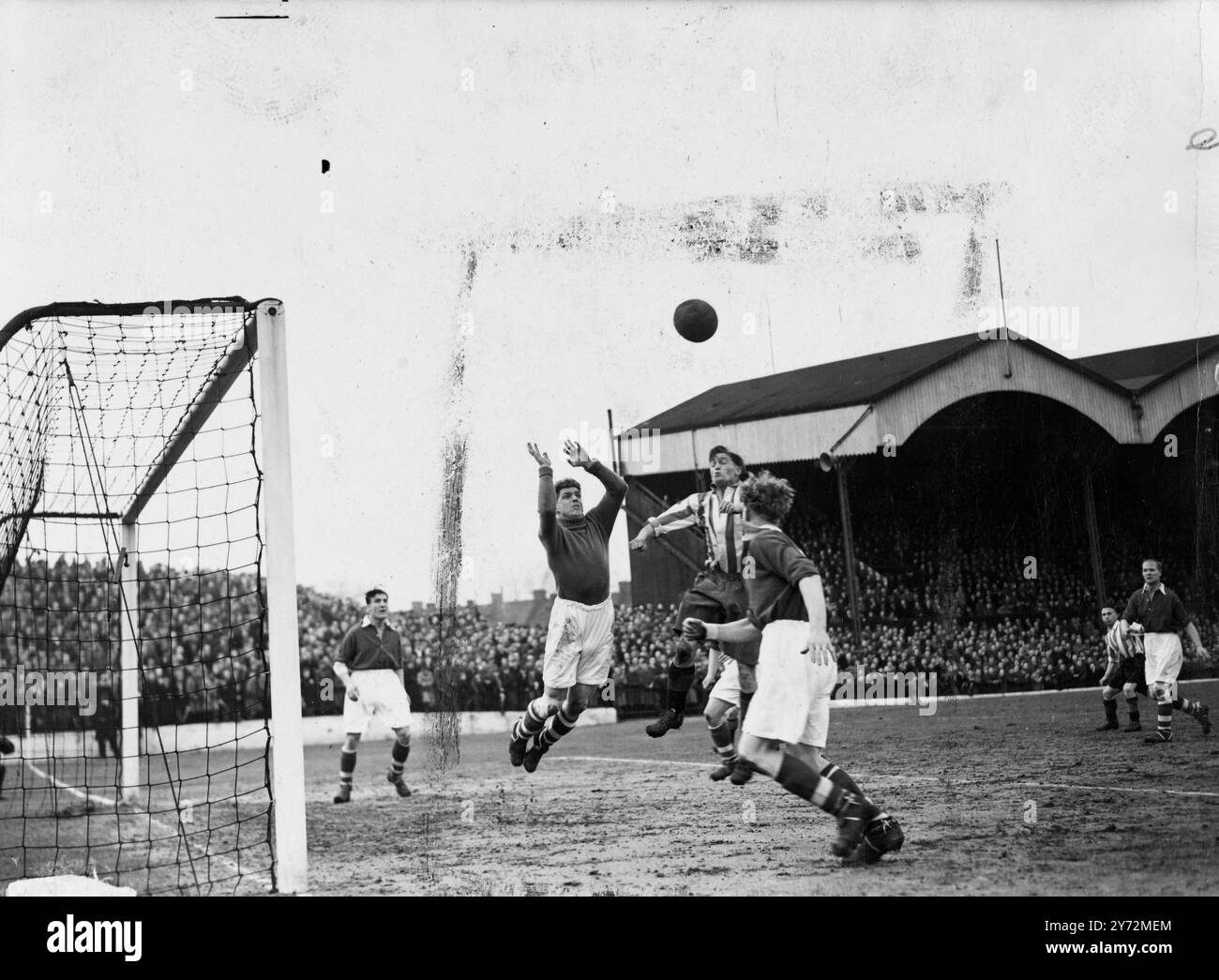 Charlton were playing at home to Brentford at the Valley today. Picture shows:  Bartram, Charlton's goalkeeper, goes out to save from Blakeman, Brentford forward, as Phipps Charlton centre half, guards the past to the goal, at today's match at the Valley.  22 March 1947 Stock Photo