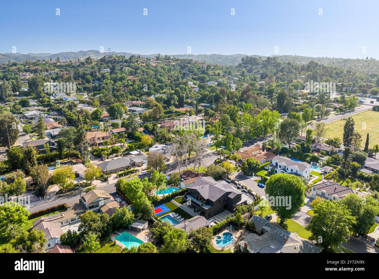 Aerial view of a suburban neighborhood with lush greenery and houses ...