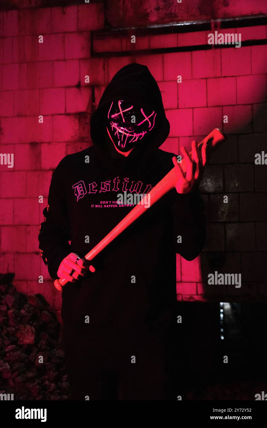 A creepy masked character of the purge anarchy with a baseball bat Stock Photo