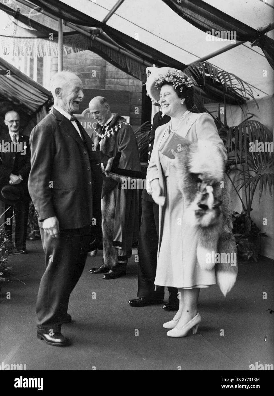 Their Majesties in Cheshire. The King and Queen today made a 30 mile drive through some of the most thickly populated areas of Cheshire. Alighting from the Royal Train at Stalybridge, where the station was decorated with a profusion of flowers. Their Majesties drove through streets lined with cheering crowds to Dukinfield, Hyde, Bredbury, Hazel Grove, Wilmslow, Hale and Altrincham, where, at the Churchill Tool Co's factory, a number of prominent local people were presented to them. After lunch, their Majesties continued their tour to Chester.  Picture shows, the man who made the King and Queen Stock Photo