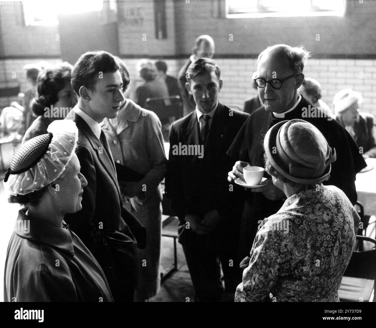 In order to save his parishioners a lot of walking from the outlying estates the Rev P Churton Collins has provided a bus service for his early services . In addition , breakfasts are also served in the church hall after the service . He is seen here chatting informally with his congregation . 24 May 1959 Stock Photo