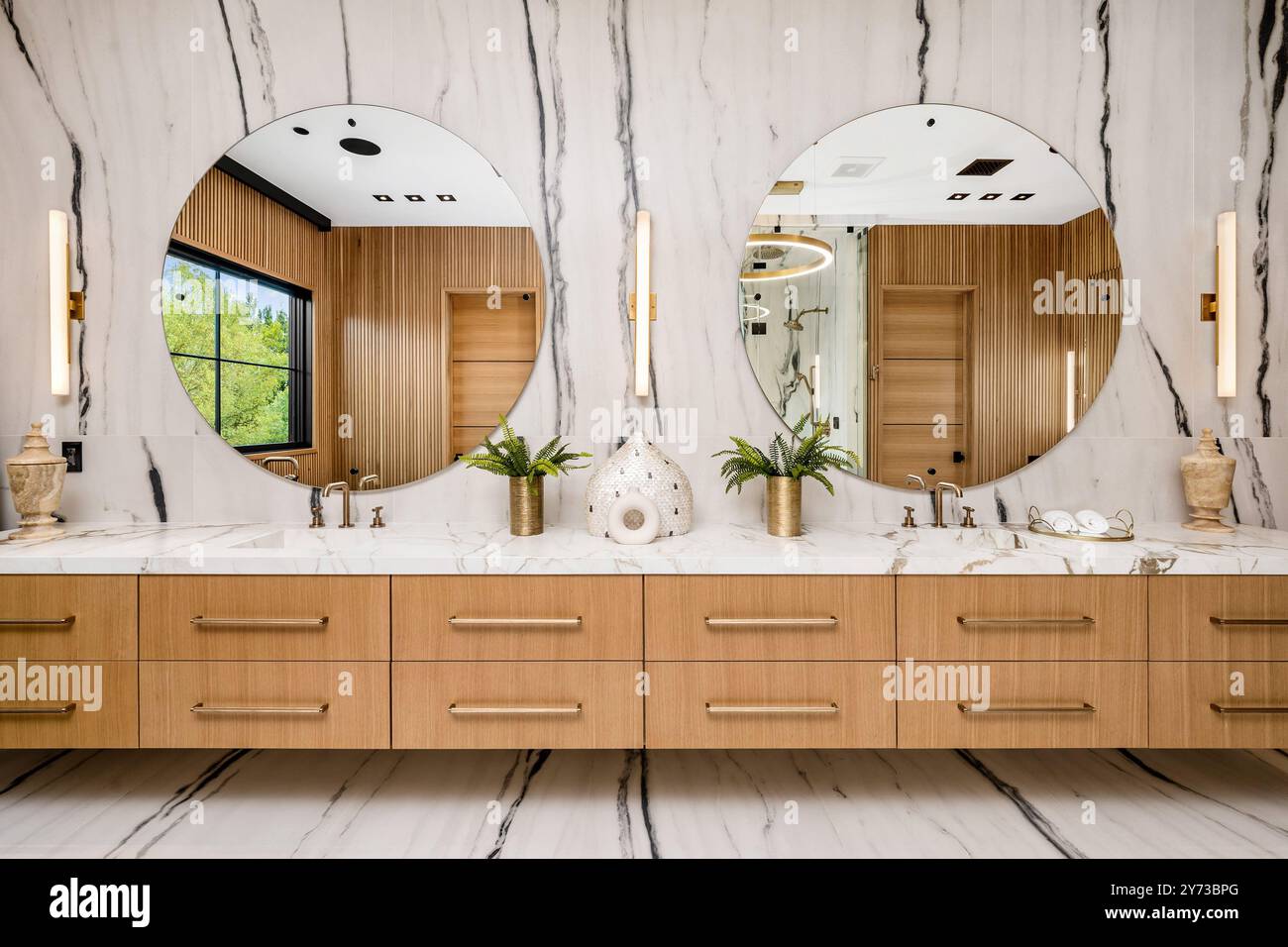 Modern bathroom with double vanity, round mirrors, wooden cabinets, and ...