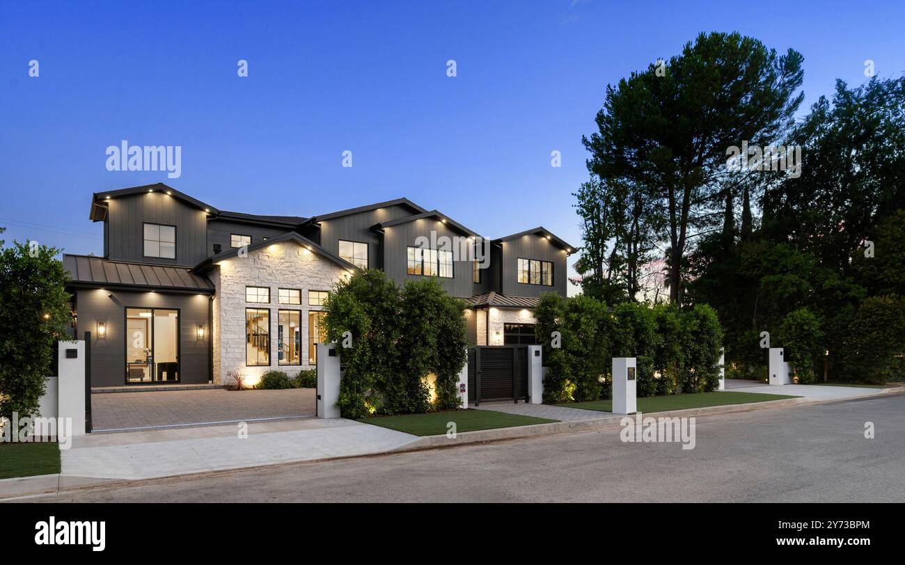 Modern luxury house exterior at dusk with illuminated facade, driveway ...