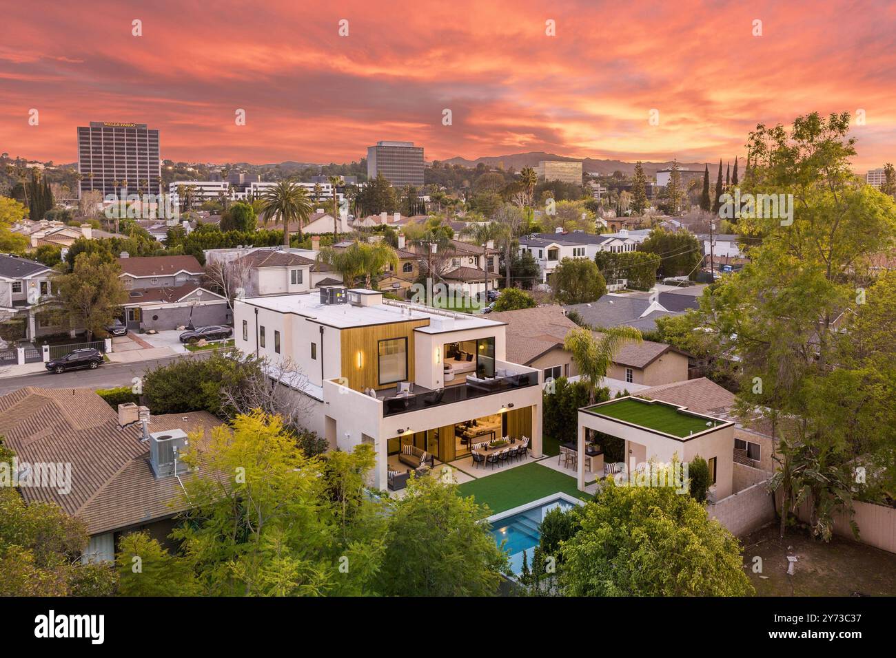 Aerial view of a modern house with a swimming pool and lush greenery at ...