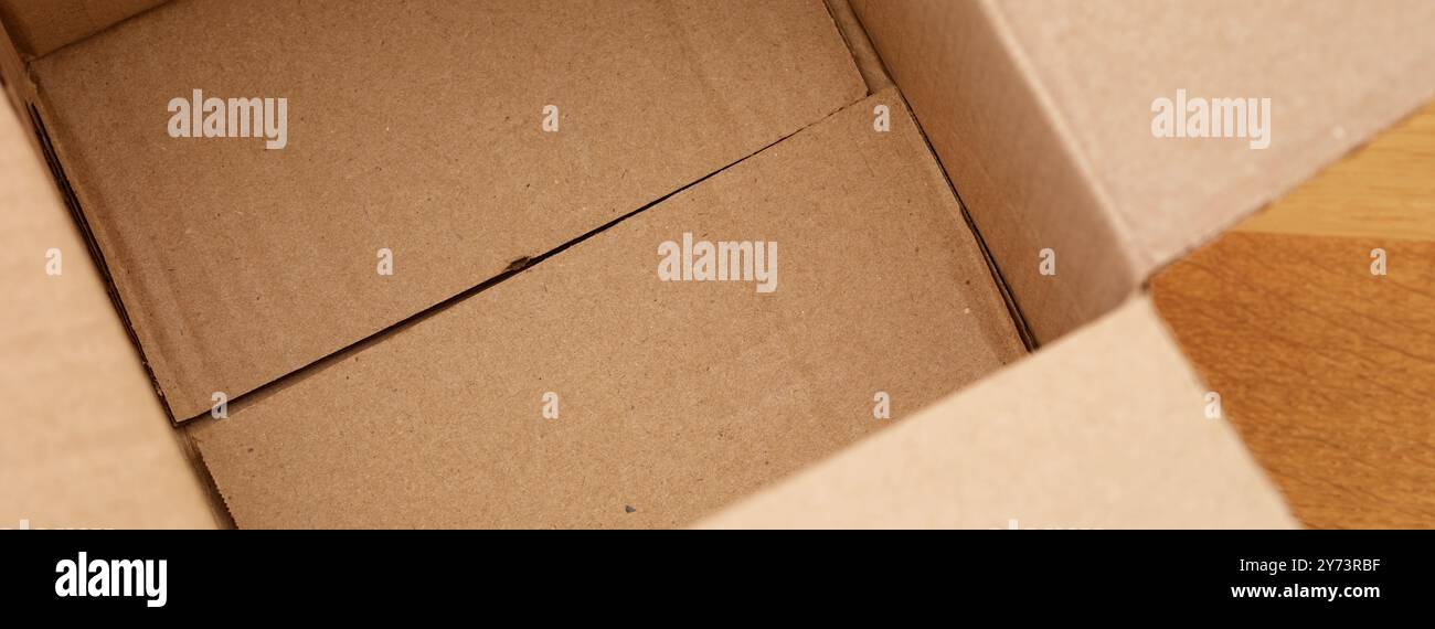 Empty cardboard box a wooden floor. Close up. Stock Photo