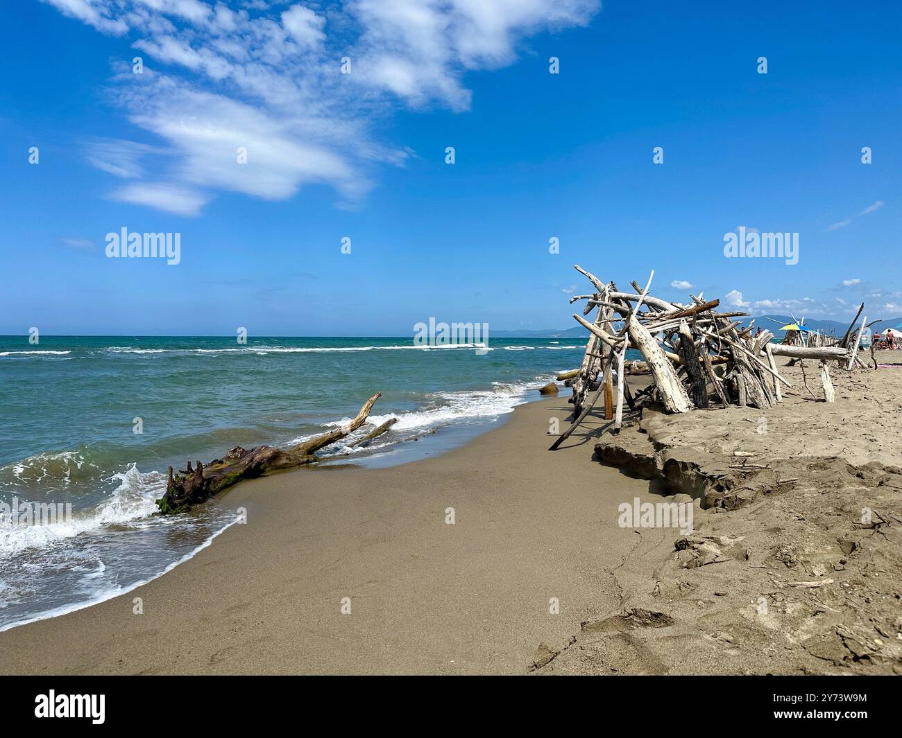 The photograph features a wooden detail on the beach, with the sea in the background during summer. - Smartphone Captured Stock Image