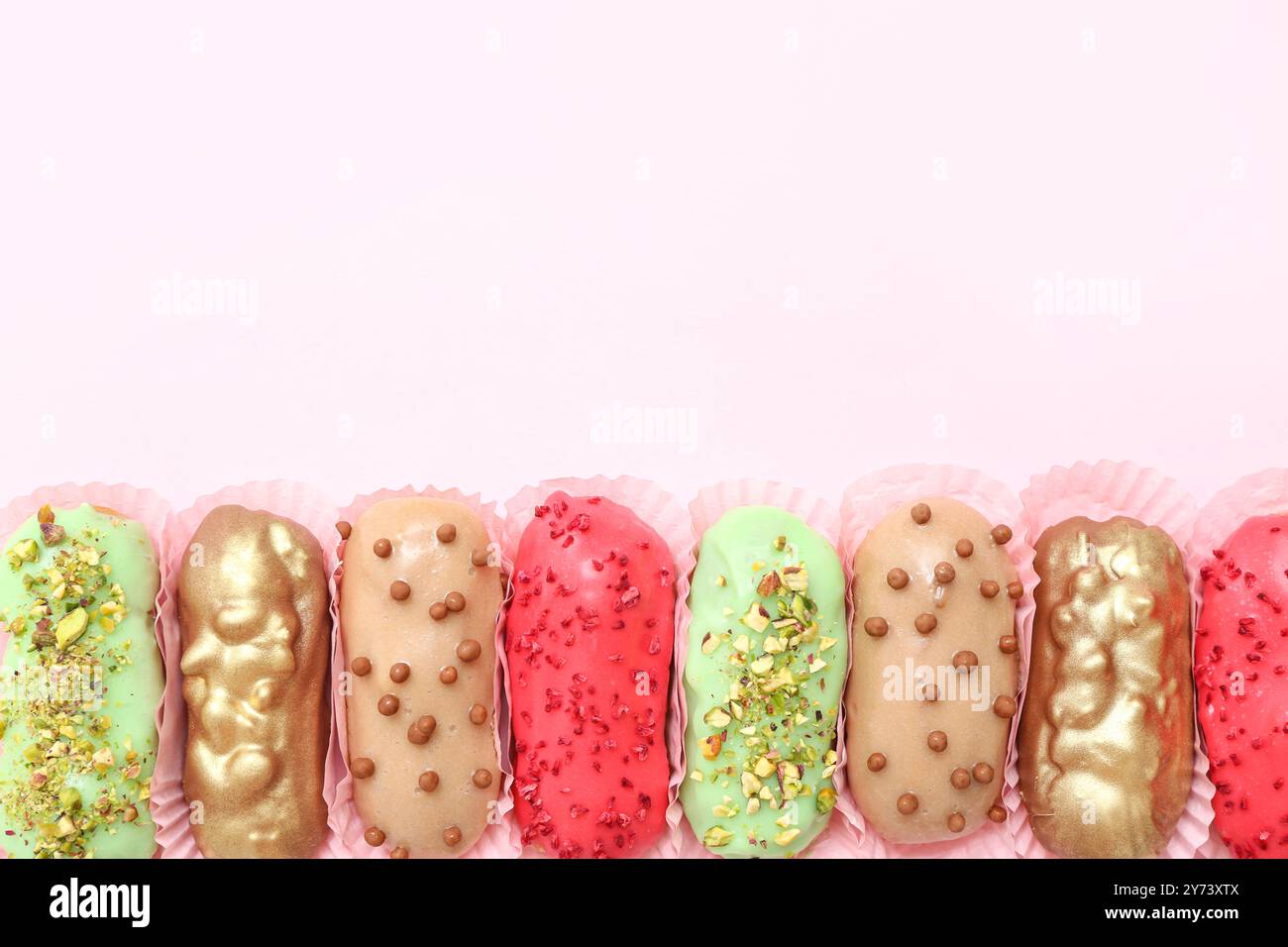Various glazed eclairs on pink background Stock Photo