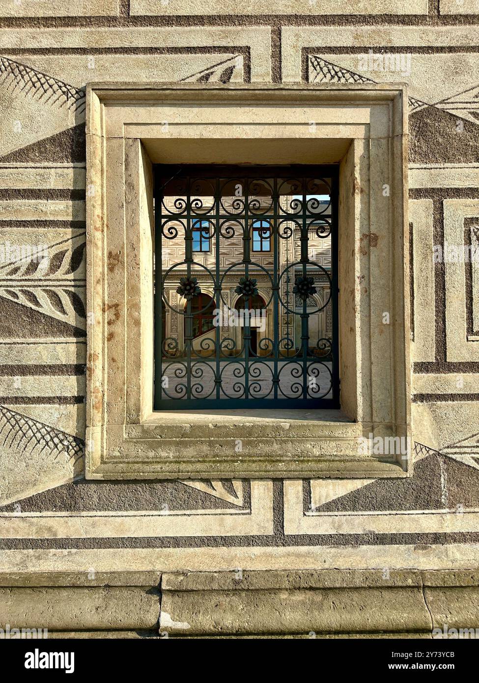 The photograph captures a detailed view of an old medieval gate made of wood and metal, set in the streets of a historic European city. - Smartphone Captured Stock Image