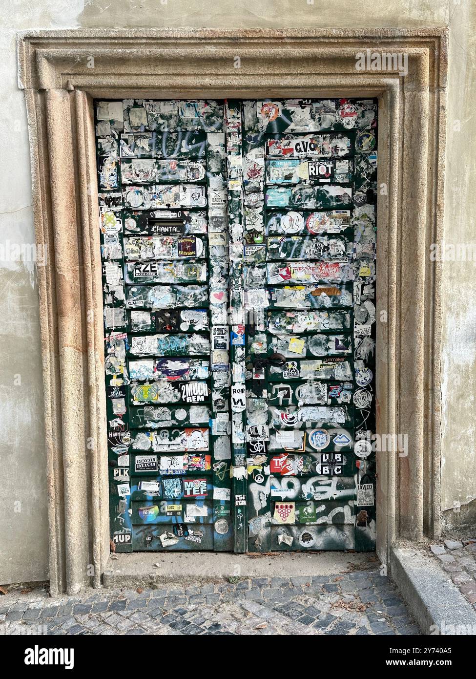 The photograph captures a detailed view of an old medieval gate made of wood and metal, set in the streets of a historic European city. - Smartphone Captured Stock Image