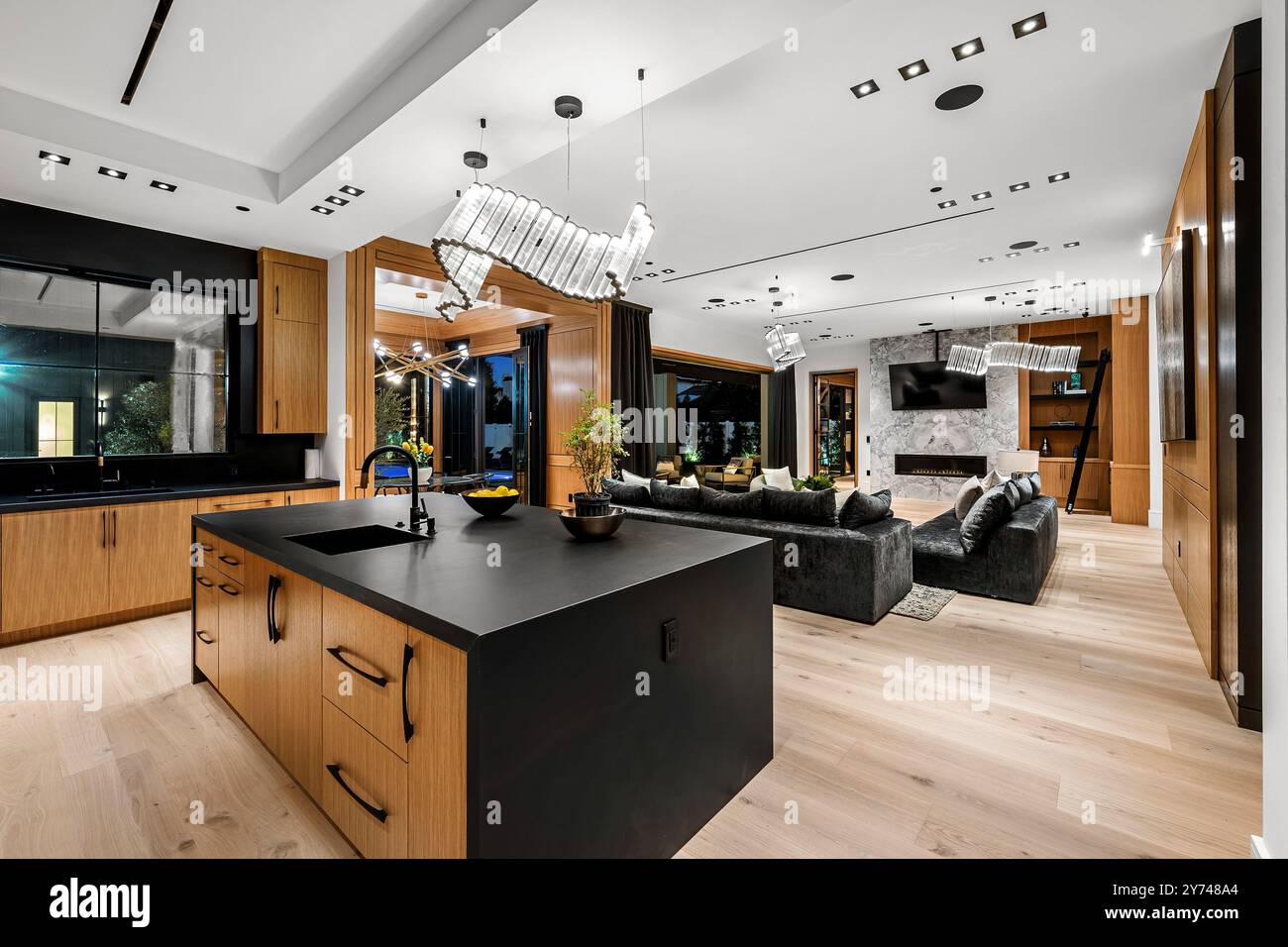 Modern open-plan kitchen and living room with sleek wooden cabinetry ...
