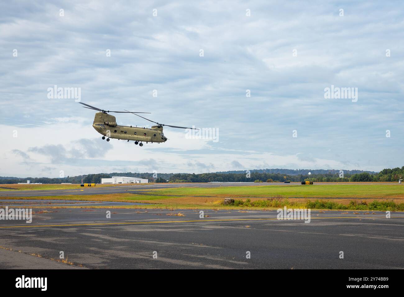 A CH-47F Chinook transport helicopter from the 1st Battalion, 169th Aviation Regiment (General Support), Connecticut Army National Guard, takes off from the Connecticut Army National Guard Army Aviation Support Facility, Windsor Locks, Connecticut, Sept. 27, 2024. The aircraft and its five soldier crew are flying down to North Carolina at the request of the North Carolina National Guard to support disaster relief operations in response to Hurricane Helene. Their week-long mission will be to aid in the transportation of food, water and other supplies. (U.S. Army photo by Sgt. Matthew Lucibello) Stock Photo