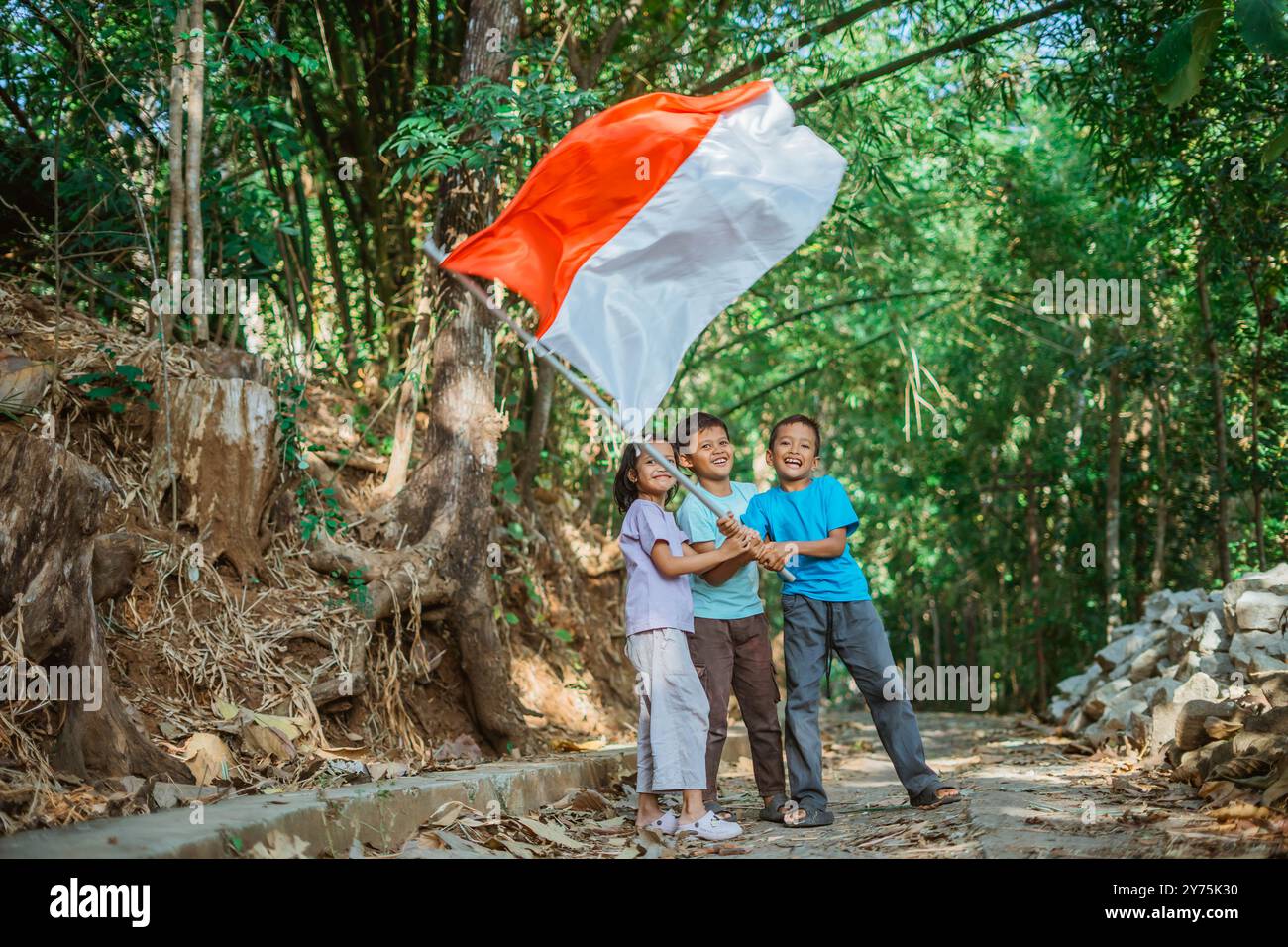 young girl and boys holding and waving indonesian flag Stock Photo