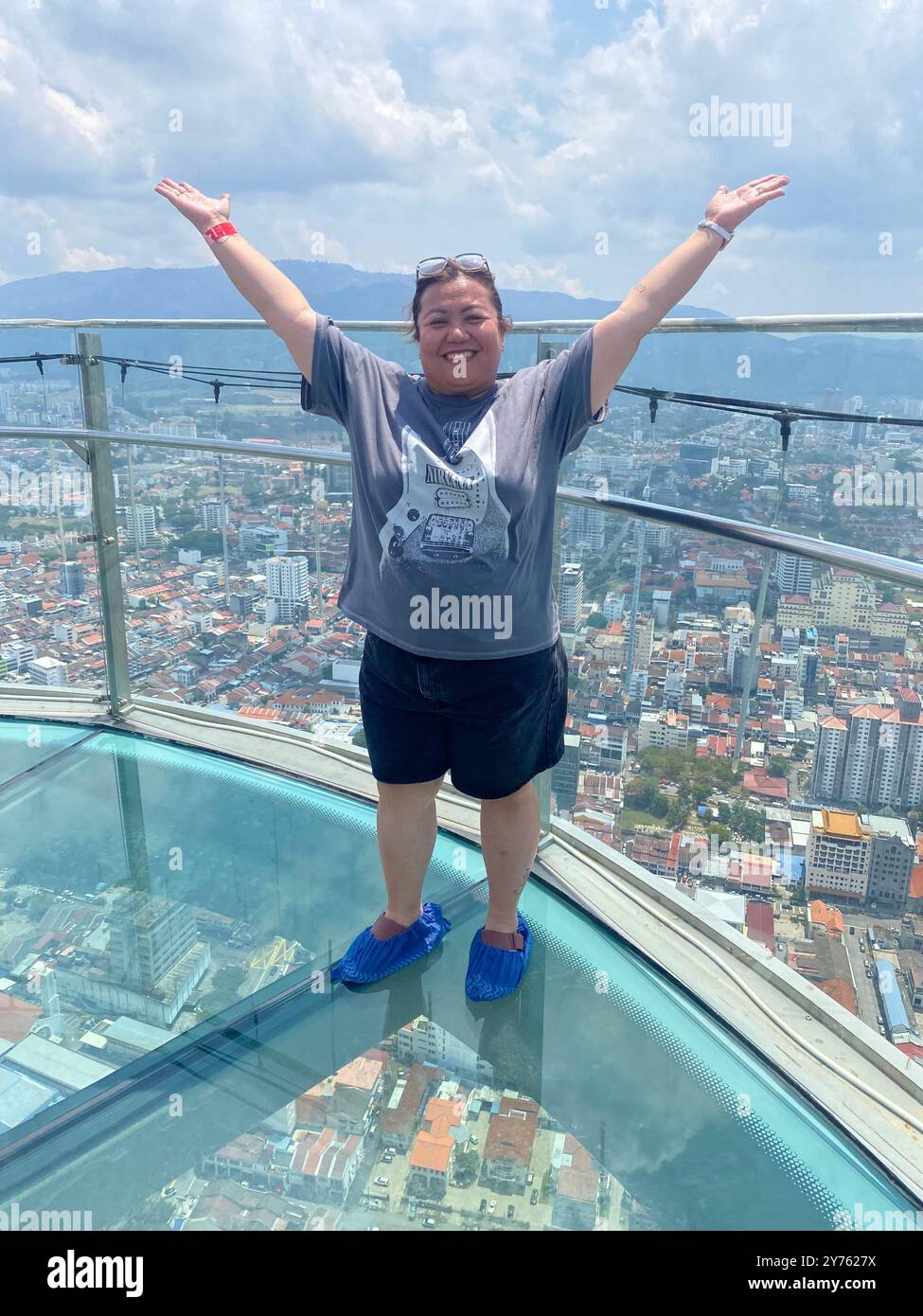 A lady poses for a photograph on the rainbow walkway, a tourist attraction at 'The Top', Komtar Tower, George Town, Penang, Malaysia - Smartphone Captured Stock Image