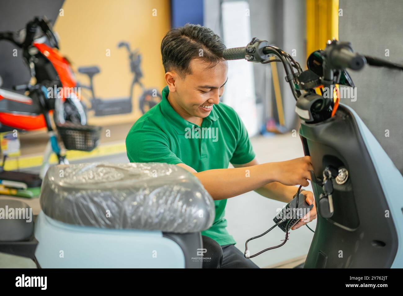 electric motorcycle charged charging station male asian Stock Photo - Alamy - Motorcycle Electric Charging Station
