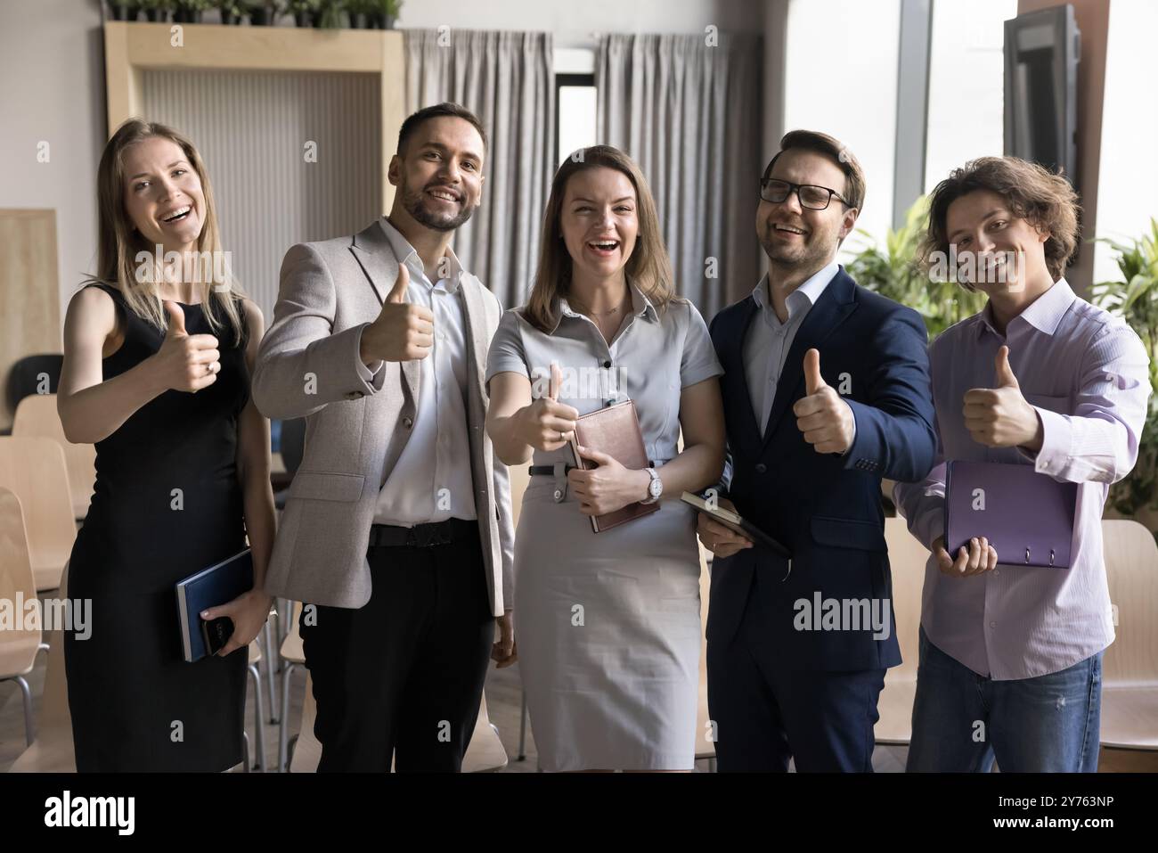 Happy business team making thumb up gesture, looking at camera Stock ...