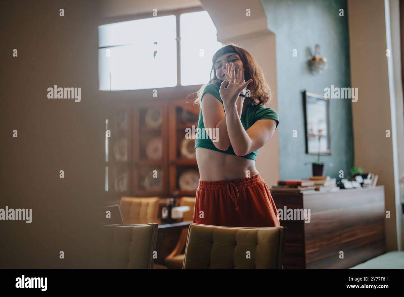 Young woman dancing expressively in cozy living room setting Stock ...