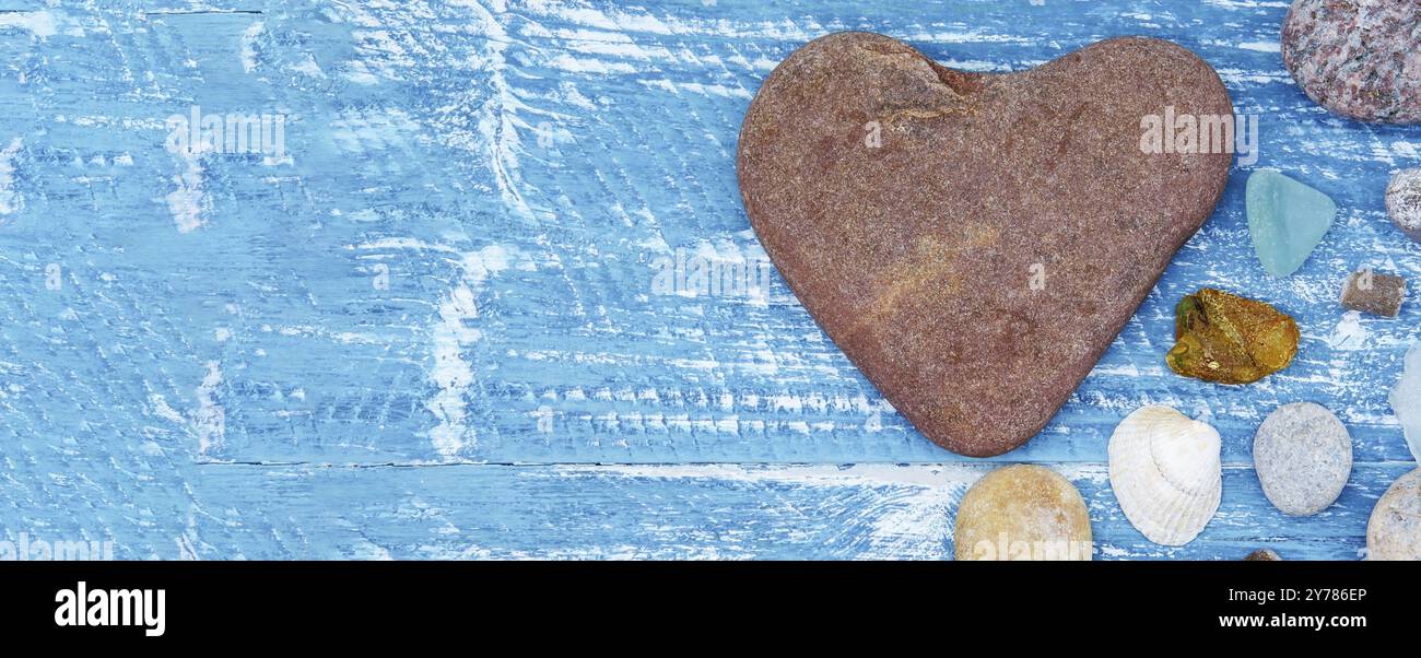 Sea pebbles and seashells on the table. A pyramid of sea stones on a blue background Stock Photo