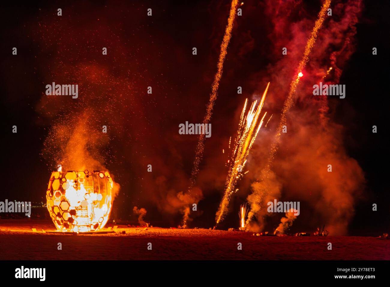 Bournemouth, Dorset, UK. 28th September 2024. Thousands flock to Bournemouth for the Arts by the Sea Festival festival finale brought forward to tonight, rather than tomorrow night because of the bad weather forecast. Pyrite Creative’s The Honey Pot structure on East Cliff Zig Zag is set alight in a mesmerising spectacle set to a backdrop of dazzling fireworks. Honeypot is a honeycomb-shaped structure, together with a torchlight trail along the Promenade bringing together different communities to mark the change in seasons and celebrate our community. Credit: Carolyn Jenkins/Alamy Live News Stock Photo