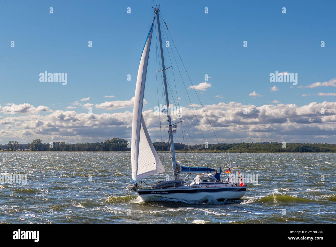 The skipper of a sailing boat greets the passenger ship Weisse Düne on its journey through the lagoon of the Peenestrom, the so-called Achterwasser. Sailing yacht in the coastal waters of Mecklenburg-Vorpommern, Germany Stock Photo