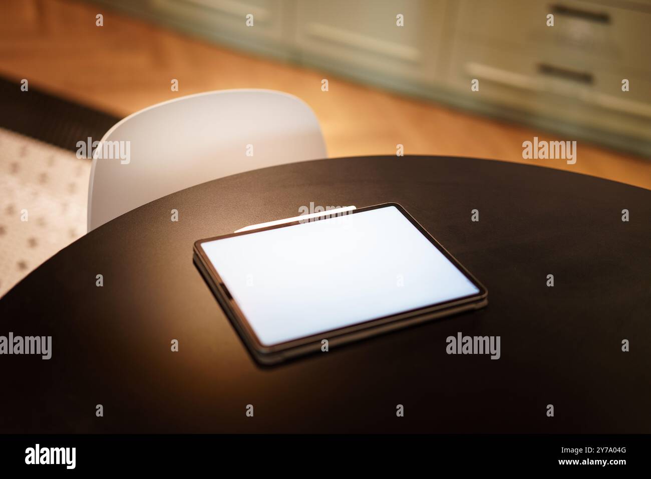 Home kitchen table. Graphic tablet computer. Blank screen reader mockup. Real estate interior. Stock Photo