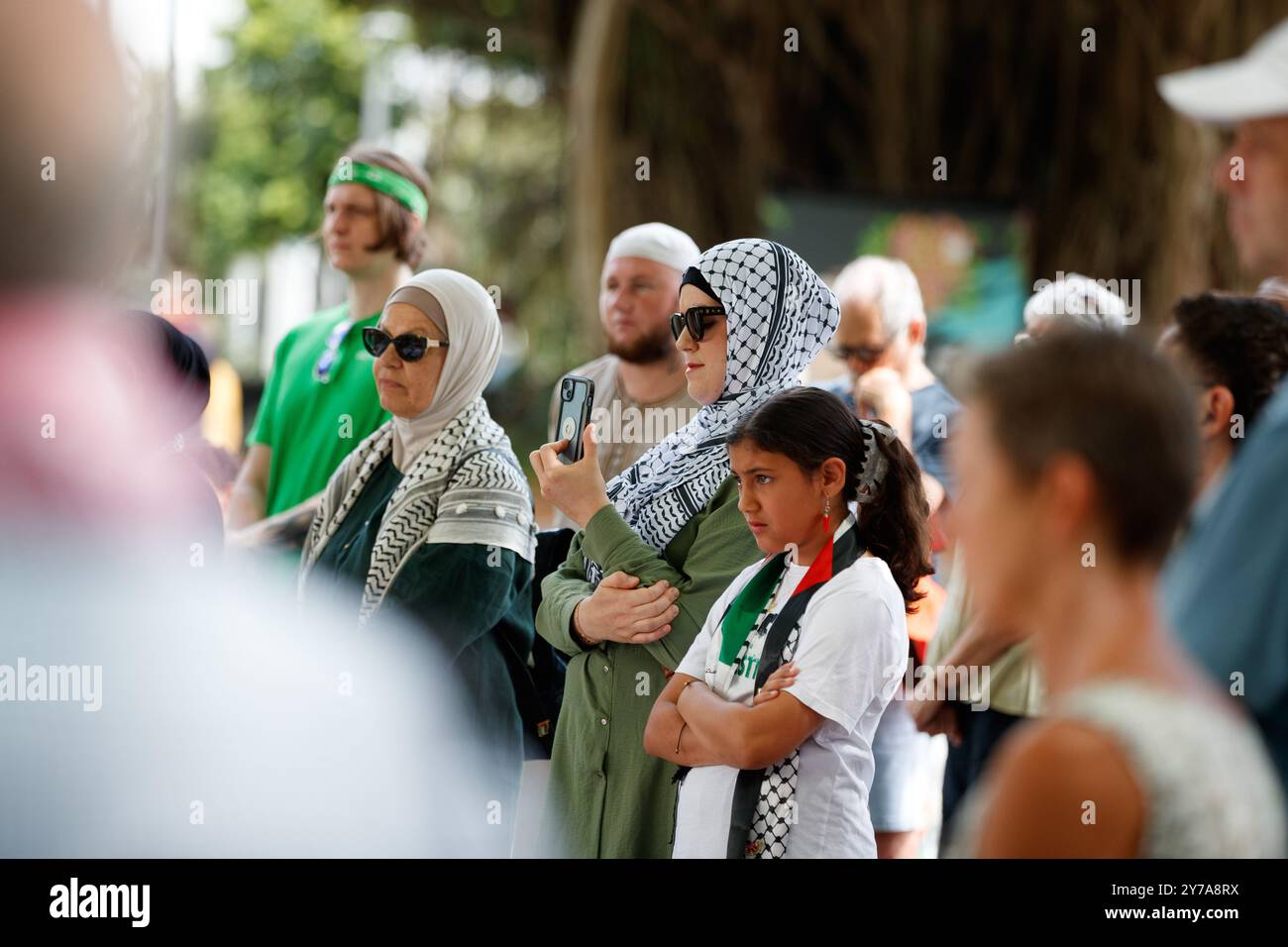 The crowd listens on as Doctor Akil Islam speaks with the crowd at a ...